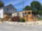 Custom home builder Muskoka projects: a modern wooden deck and sunroom addition on a grey house.