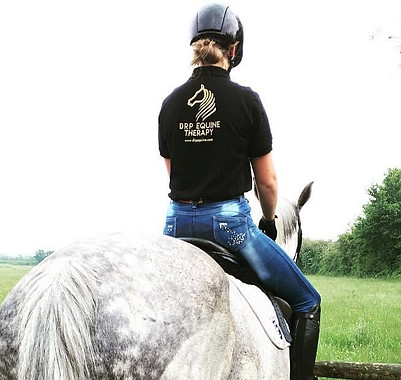 Dominica Rogan-Pfaff riding her horse showing the DRP Equine Therapy Logo