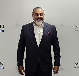 The Boss, Peter, smiling happily in front of the Michigan Department of Education Banner.