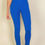 Thumbnail: A person wearing bright blue, high-waisted fitted leggings and a matching blue top is standing against a plain, light-colored