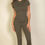 Thumbnail: A woman stands against a plain light-colored wall, wearing a fitted, short-sleeved olive green top and matching pants.