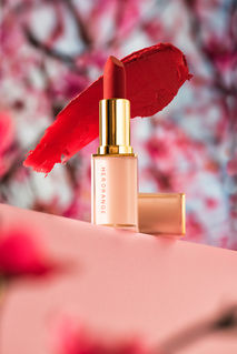 Product photography of red lipstick with swatch on pink background