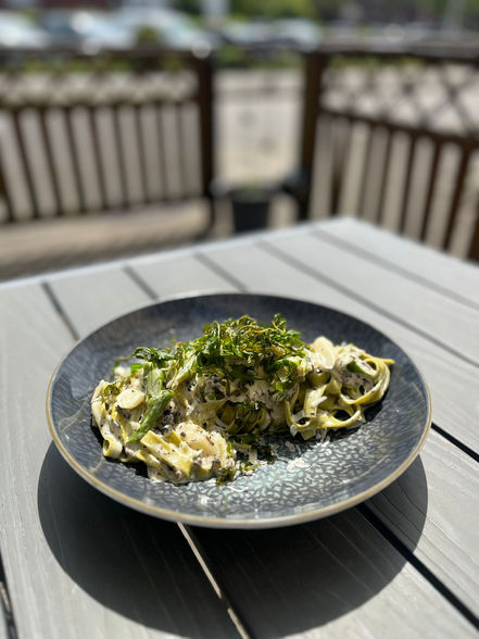 Teller Pasta mit grünen Kräutern auf Außenterrasse