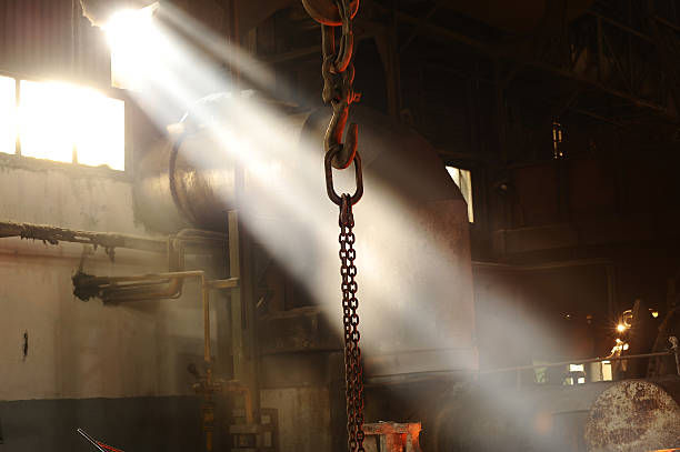 Tampak sebuah electric chain hoist Elephant beroperasi di area industri, mengangkat beban berat dengan motor listrik presisi buatan Jepang.