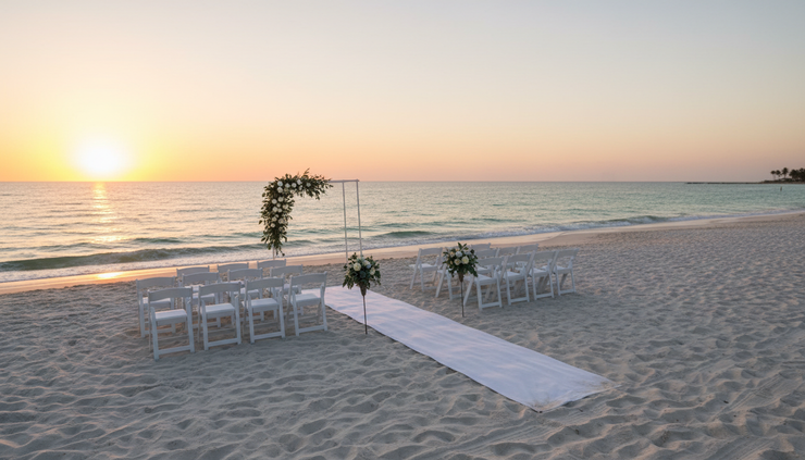 Wide-angle view of a quiet Sarasota beach ceremony setup at sunset.