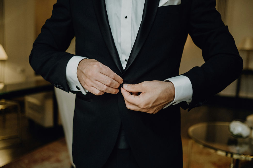 man buttoning his tuxedo suit