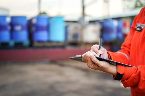 A safety officer is writing on the checklist document during safety audit workplace at the