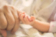 Baby holding parent pinky finger