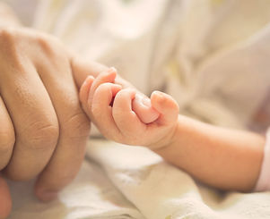 Baby holding parent pinky finger