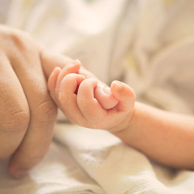 Baby holding parent pinky finger