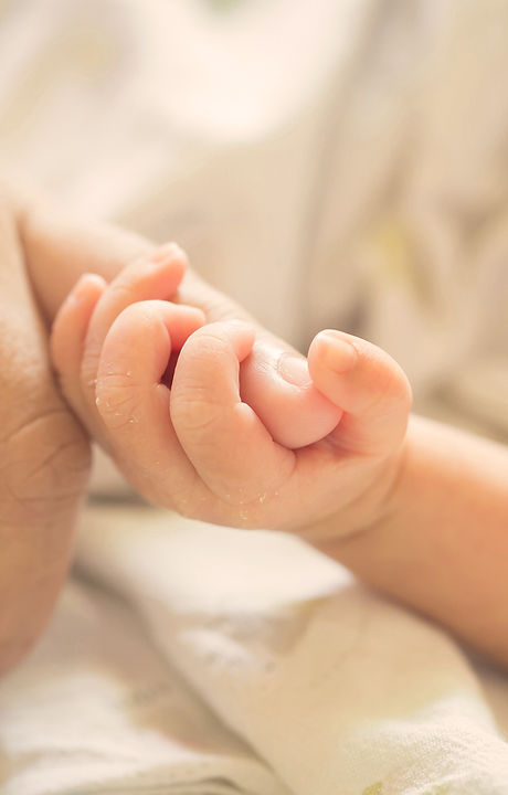 Baby holding parent pinky finger
