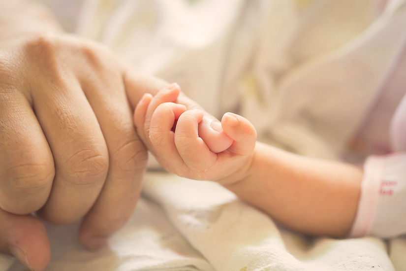 Baby holding parent pinky finger