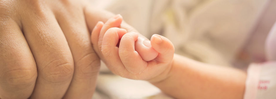 Baby holding parent pinky finger