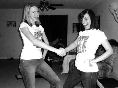 Two women wearing matching t-shirts shake hands