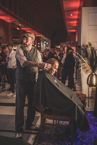 Professionele barber verzorgt een grooming behandeling tijdens een evenement