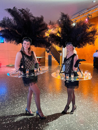 Champagnemeisjes serveren champagne aan gasten tijdens een exclusief evenement
