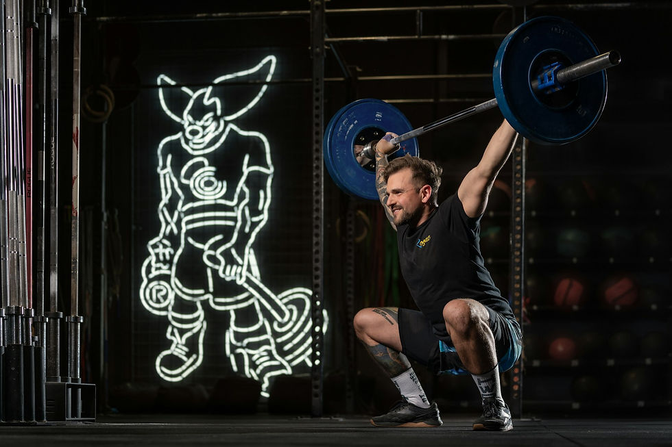 Athlete in mid-rep barbell back squat, hands gripping the bar