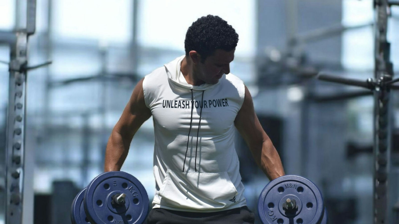 A lifter performing a dumbbell exercise in a gym