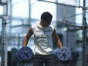 A lifter performing a dumbbell exercise in a gym