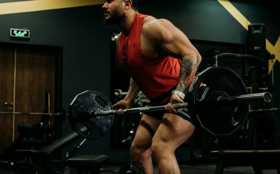 Athlete performing a controlled barbell back squat in a gym