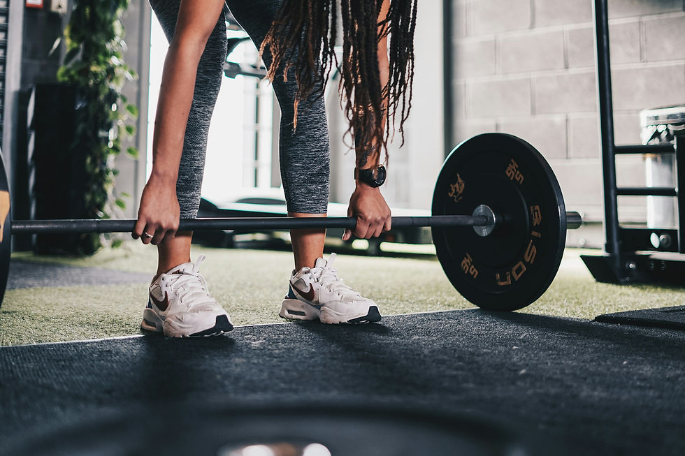 A fit woman gripping a loaded barbell in a gym, primed for an explosive lift