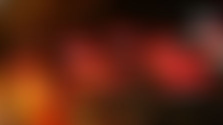 Hong Kong Immigration - Red pendant lamps with glowing white bulbs hang from a ceiling in a dim shopfront. Bags and a red item hang on the tiled wall in the background.