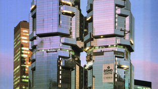 香港投资签证：未来主义风格的建筑，采用反光玻璃和棱角分明的设计，在暮色中拔地而起。