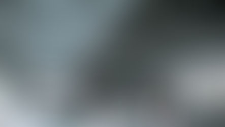 香港入境处:人们在宽敞现代的中庭内乘坐自动扶梯,中庭顶部为金属材质。柔和的灯光和光影营造出一种平静而繁忙的氛围。