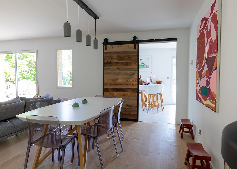 Salle à manger avec une belle porte à galandage en bois