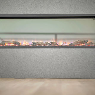 Modern horizontal electric fireplace with realistic glowing logs set into a gray textured wall above smooth floor tiles.