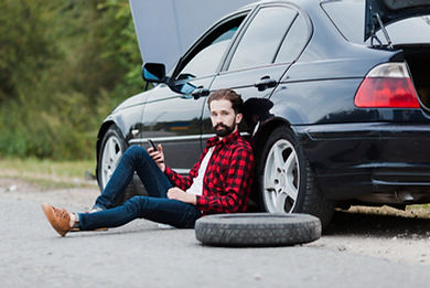 man-sitting-road-leaning-car.jpg