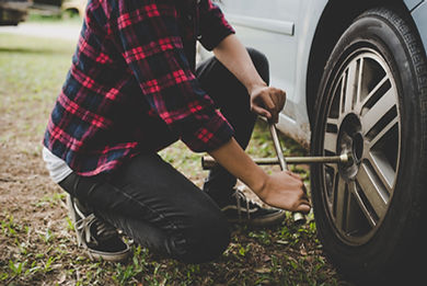 young-hipster-woman-checking-out-flat-tyre-her-car-try-fix.jpg