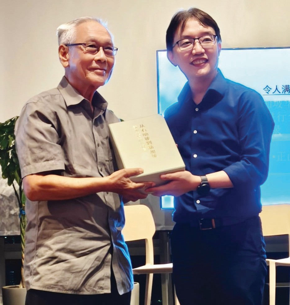 导读会终场时,主编陈志锐(右)给本文作者颁赠《新加坡华语资料库》(作家艾禺提供)。
