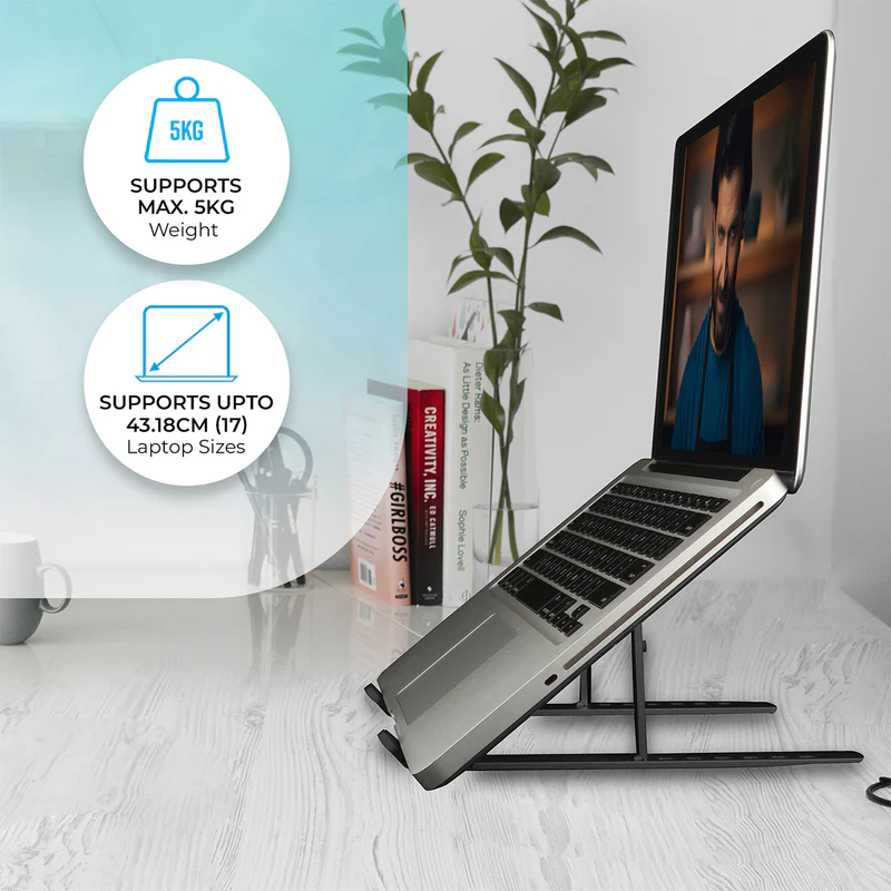 Laptop on a black stand in a modern office. Text highlights support for 5KG and up to 43.18cm size. Books and plant in the background.