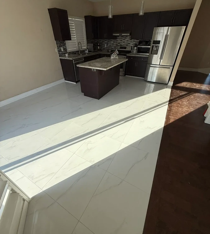 
Room with dark engineered hardwood flooring installed using glue-assist method, featuring large windows with white trim and a view of a backyard pool and landscaping.