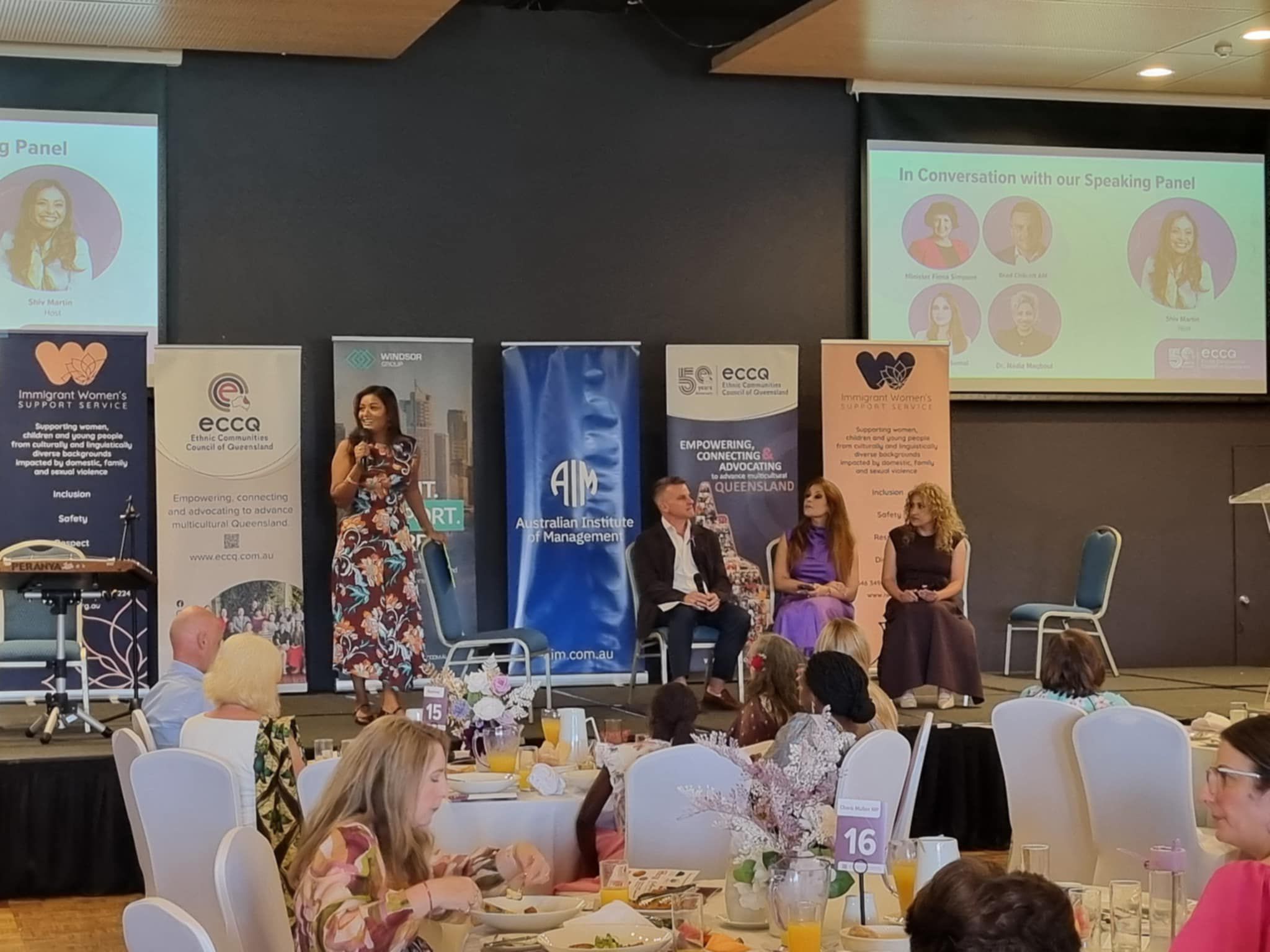 Shiv Martin speaking on stage at an International Women's Day event