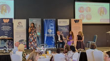 Shiv Martin speaking on stage at an International Women's Day event