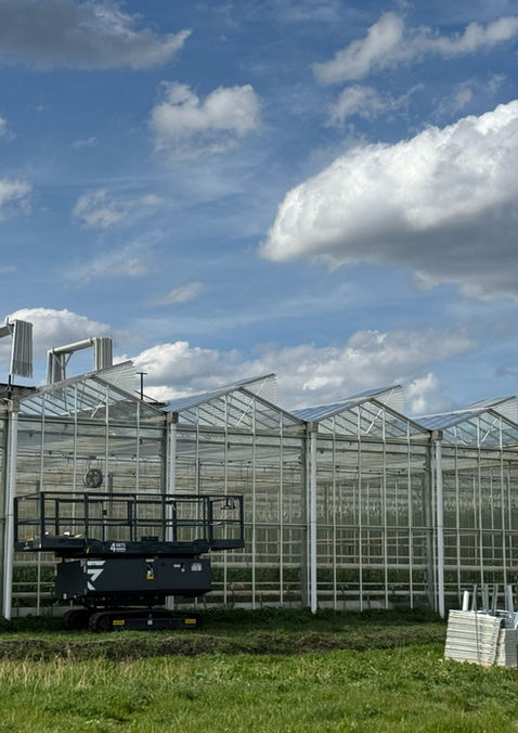 Het monteren van insectengaas in luchtramen van kassen bij project Bonnaterra. 