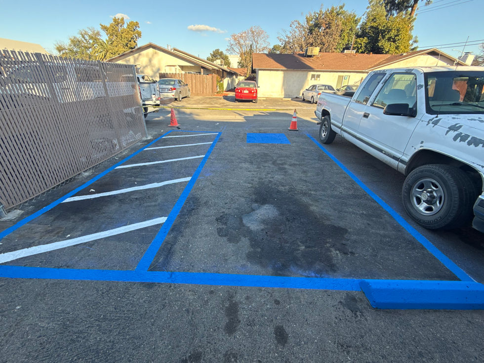Parking lot with blue lines and parked vehicles.