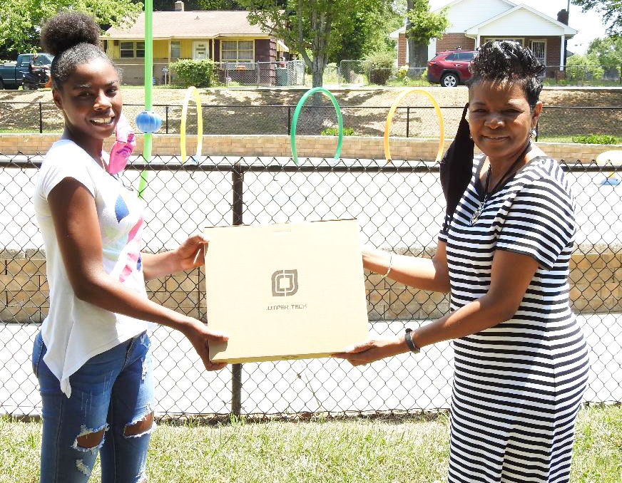 Student taking picture with karen holding new computer
