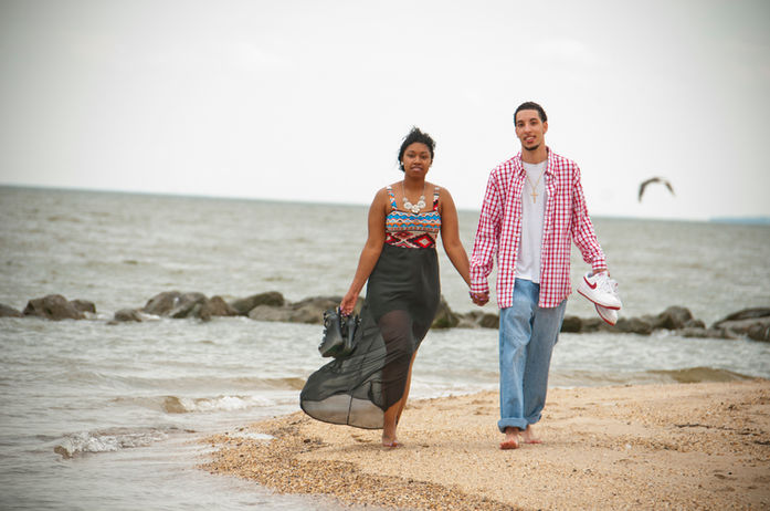 Engagement couple walking along beach in VA during engagement photography session