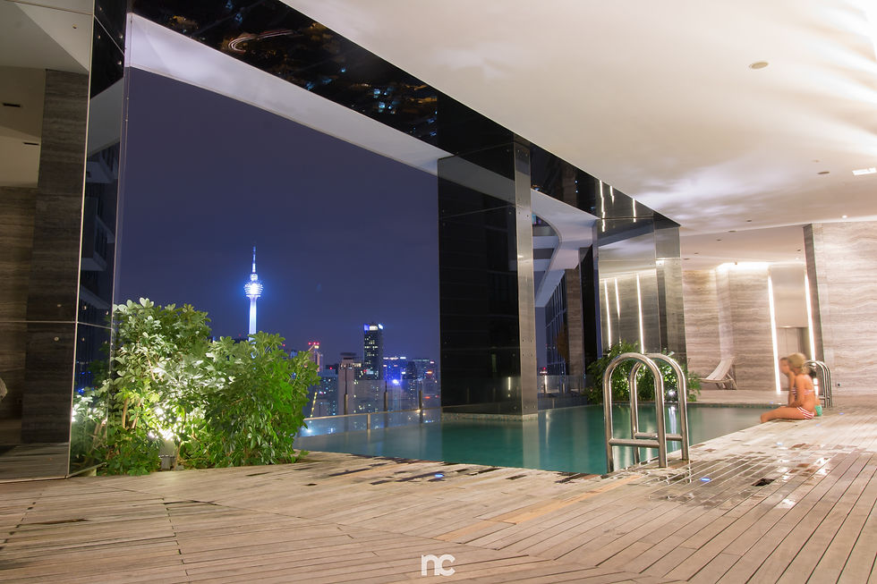 Professional commercial interior photography of a luxury infinity pool at night in Kuala Lumpur, fea