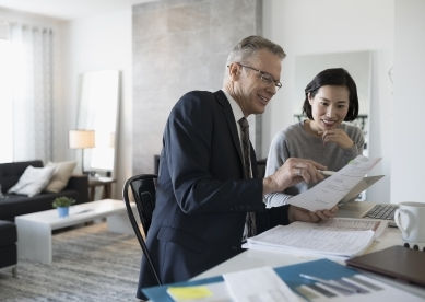 Professional discussing documents with a client in an office