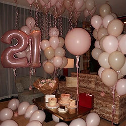 Elegant white and pastel balloon arch with backdrop for birthday party setup