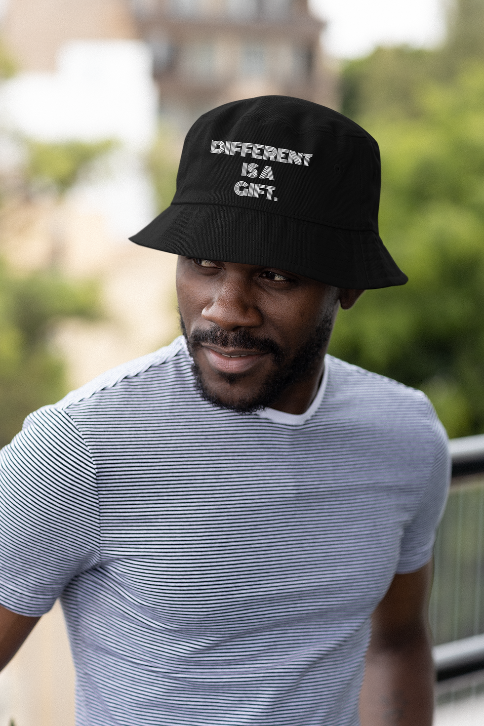 Cotton bucket hat featuring “Different is a gift.” in playful layered line typography with a flowing, dimensional look.