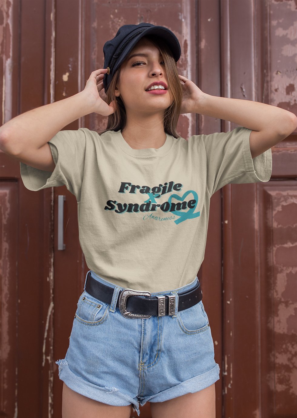 Thumbnail: Tan t-shirt with black and teal text Fragile X Syndrome Awareness.