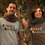 Thumbnail: Couple wearing "Gobble Gobble" T-shirts, standing outdoors during fall season.