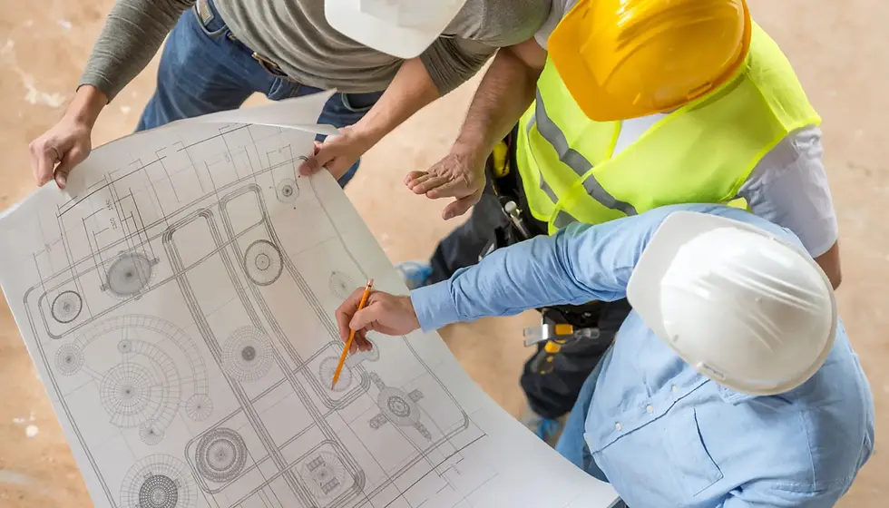 Construction professionals reviewing architectural plans, representing the expert team needed for rebuild compliance.