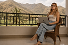AppleStar Salvador, founder of MarkeThings, working remotely on digital marketing strategy with a MacBook in a tropical balcony setting.