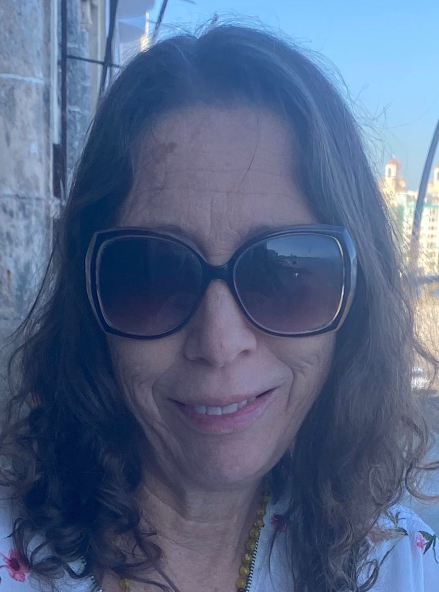 Primer plano de una mujer con gafas de sol grandes, fondo urbano